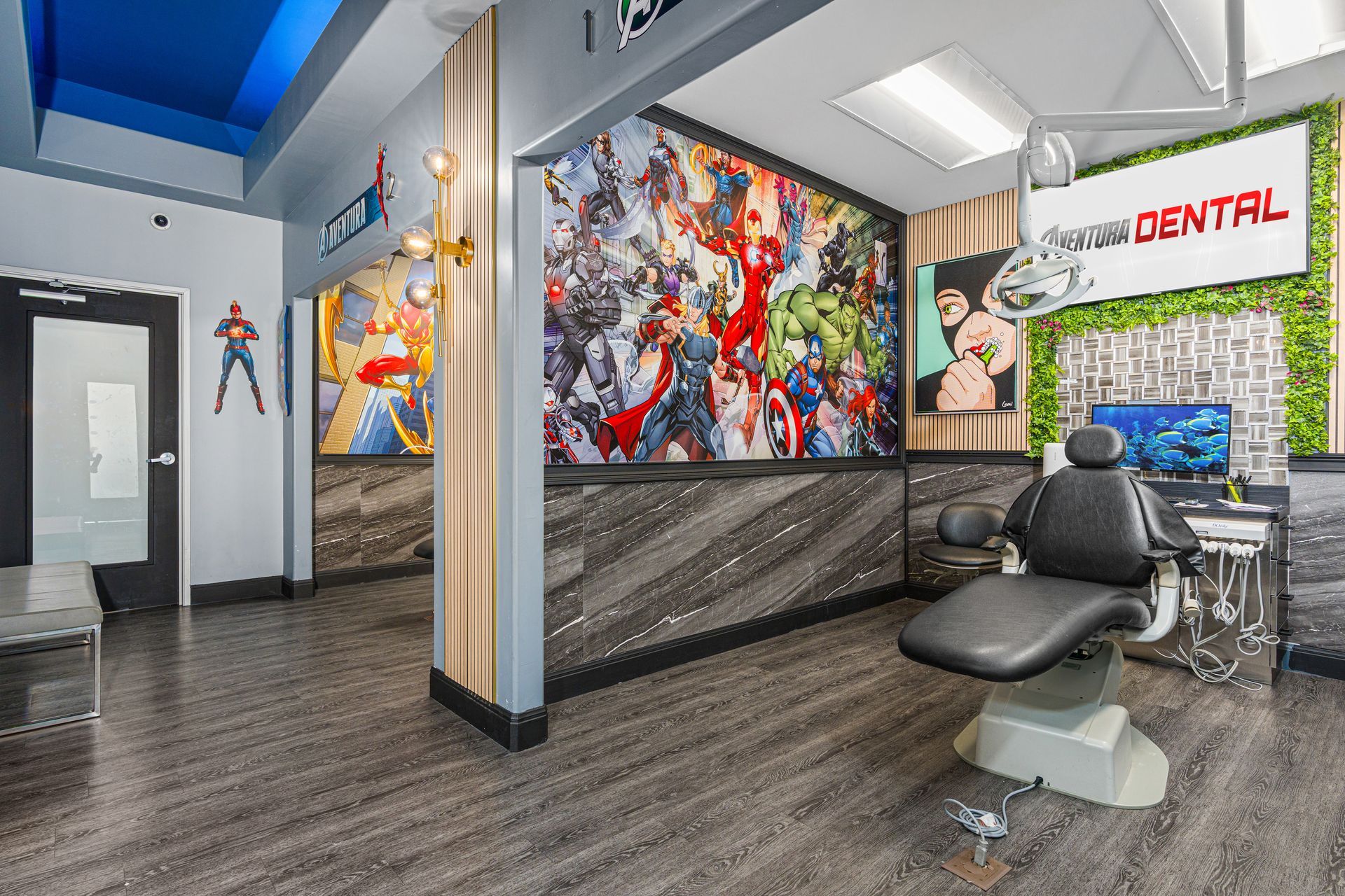 Bright dental office waiting room with black chairs, colorful wall art, and a reception desk