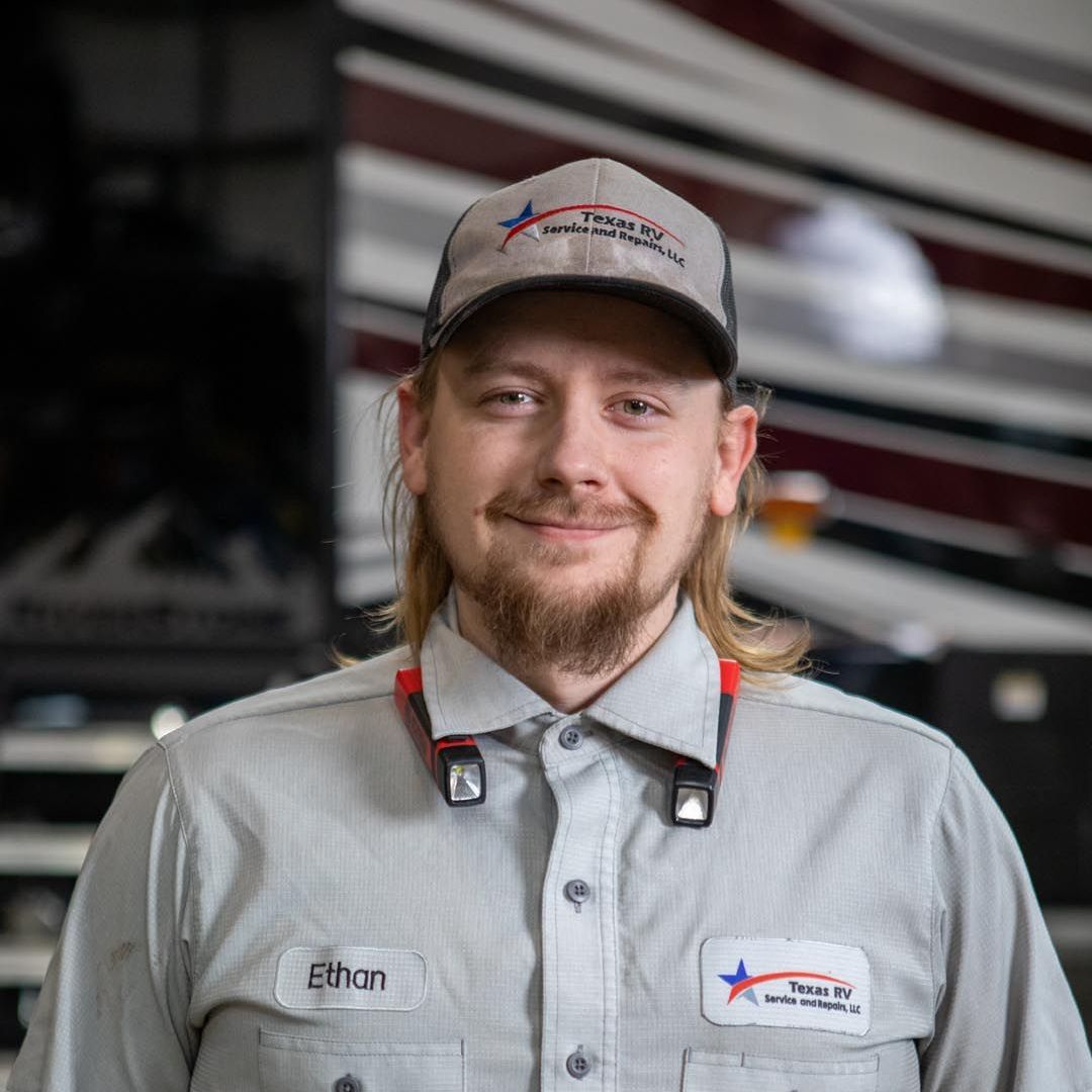 Man in grey work uniform and cap, smiling. Name tag says