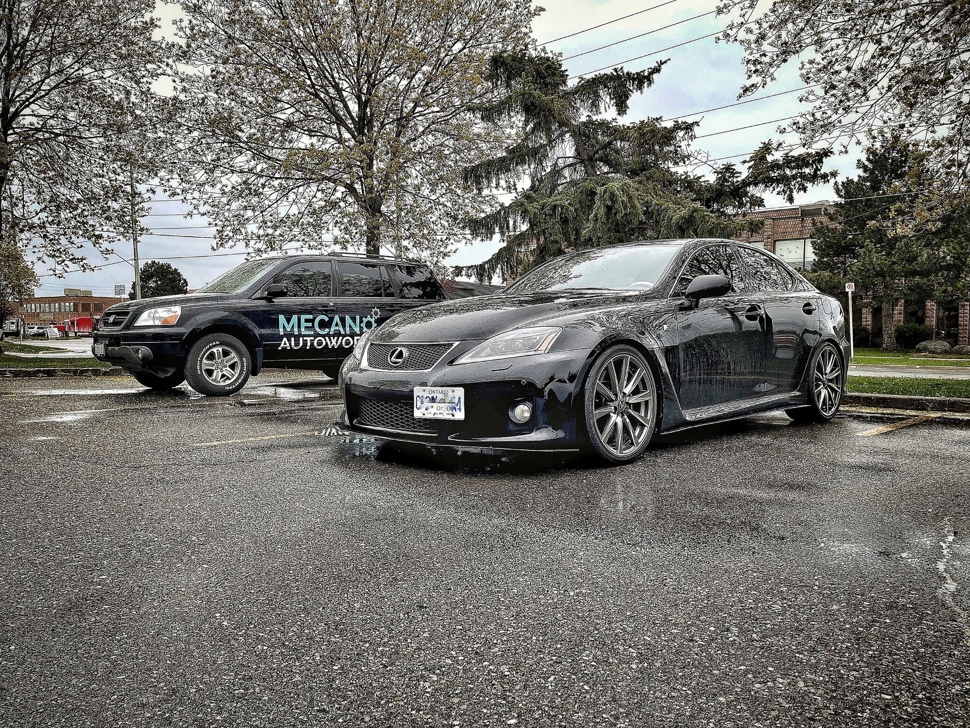 Black Lexus sedan parked next to a black SUV with 