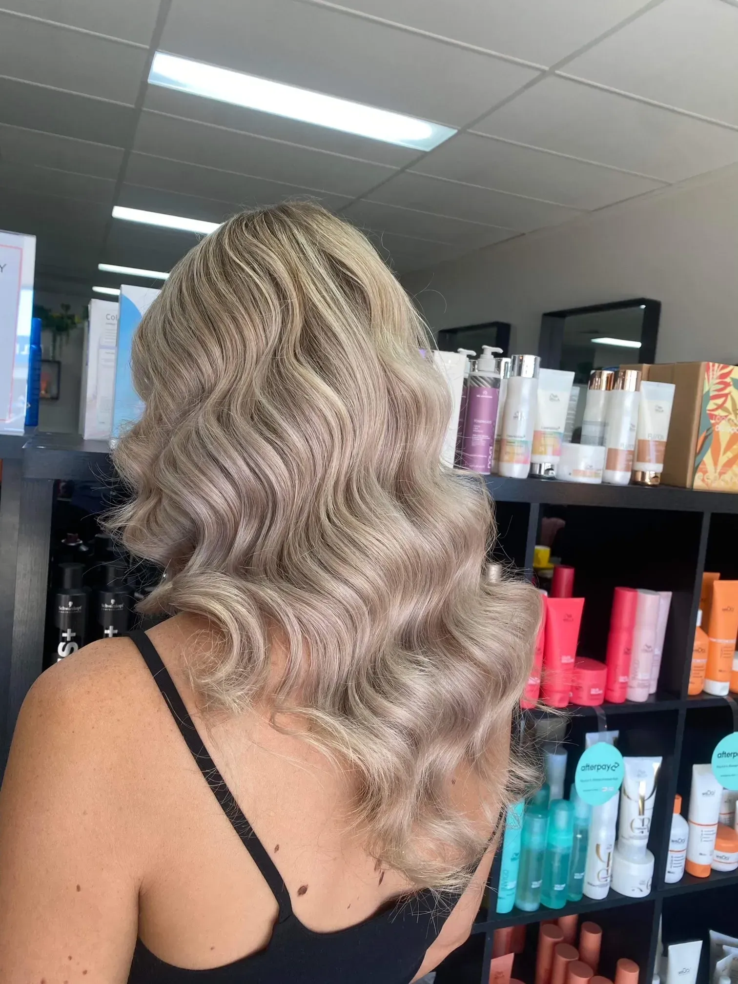 Woman with Wavy, Blonde Hair in A Salon, Facing Away from The Camera — EDISON Hair Collective In Mackay, QLD