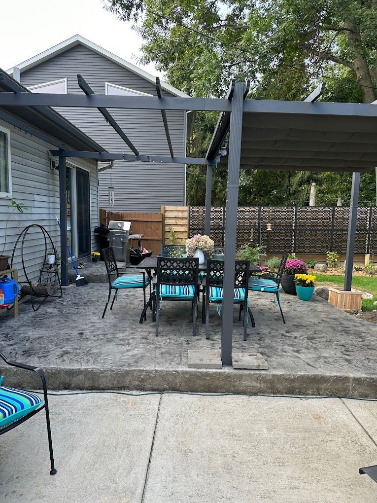 A patio with a table and chairs under a pergola.