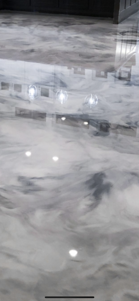 A close up of a shiny metallic floor in a kitchen.