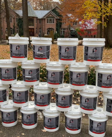 Several buckets of paint are stacked on top of each other