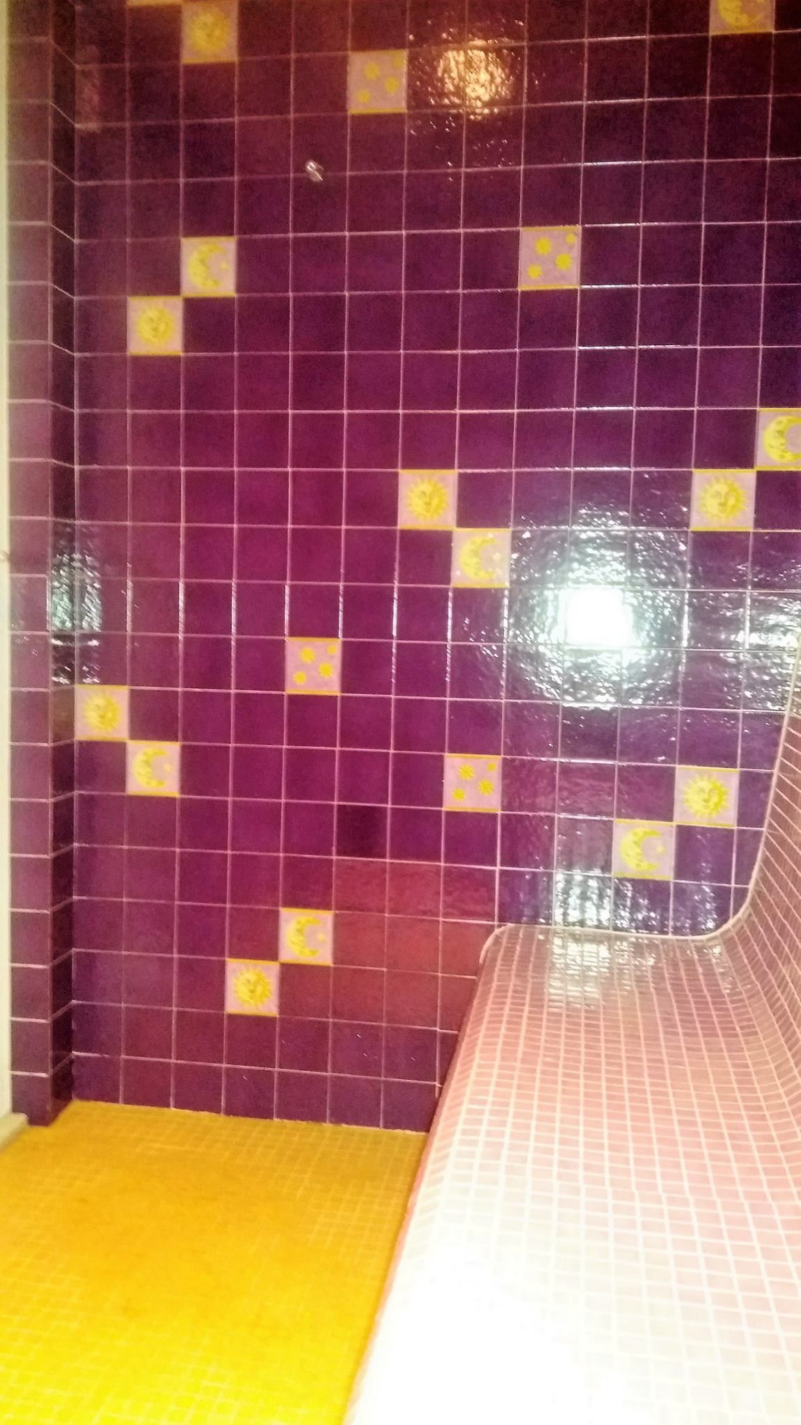 Pared de azulejos morados con pequeños detalles amarillos 