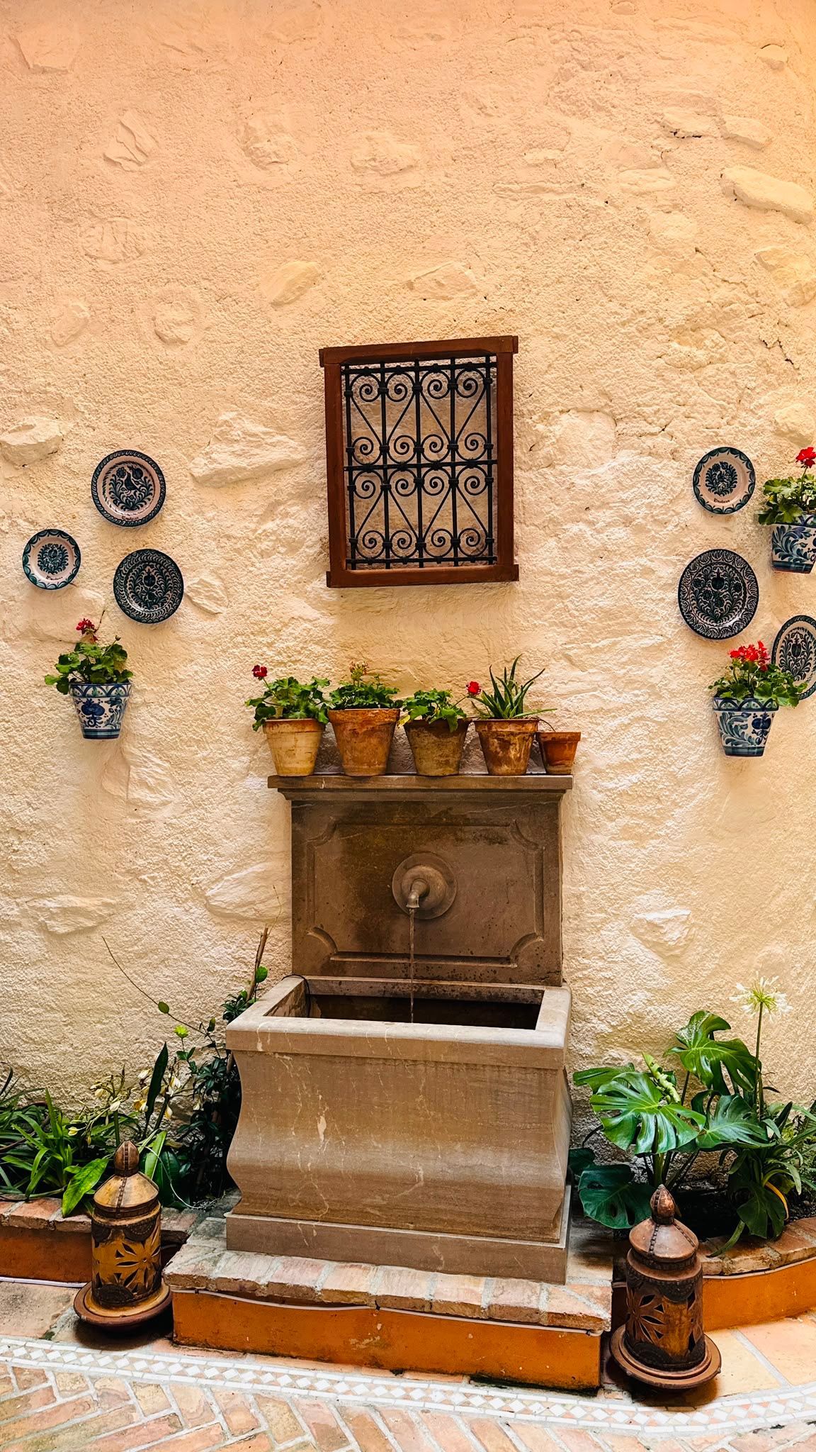Patio interior estilo andaluz con fuente ornamental.
