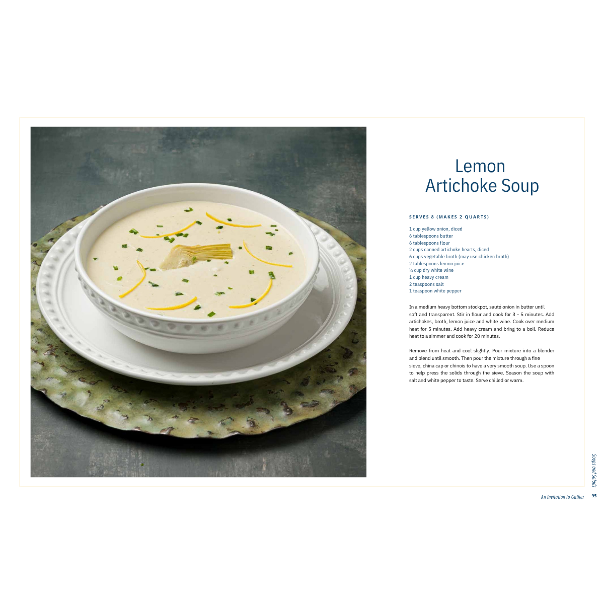 A bowl of creamy lemon artichoke soup on a white plate beside a recipe page.