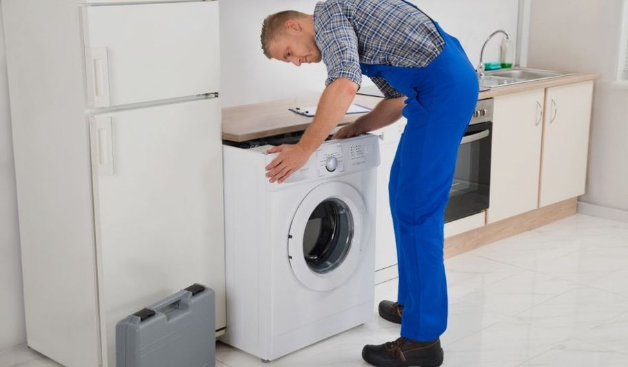 Professional electrician repairing a residential washing machine.