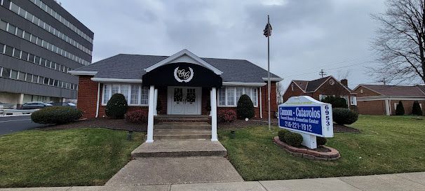 A brick building with white pillars and a sign that reads