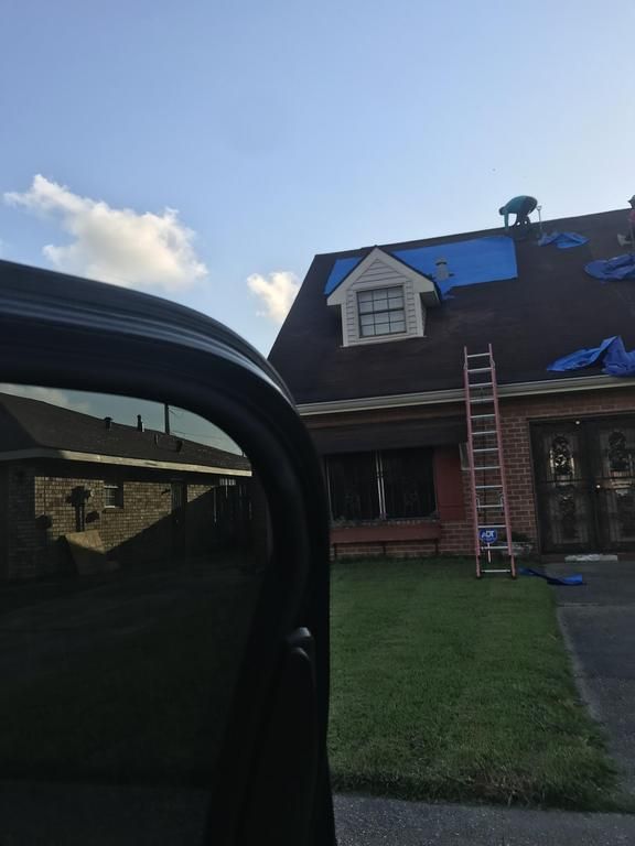 A house is being remodeled with a tarp on the roof.