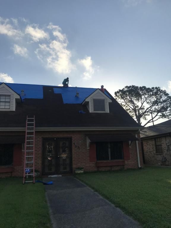A house with a blue tarp on the roof