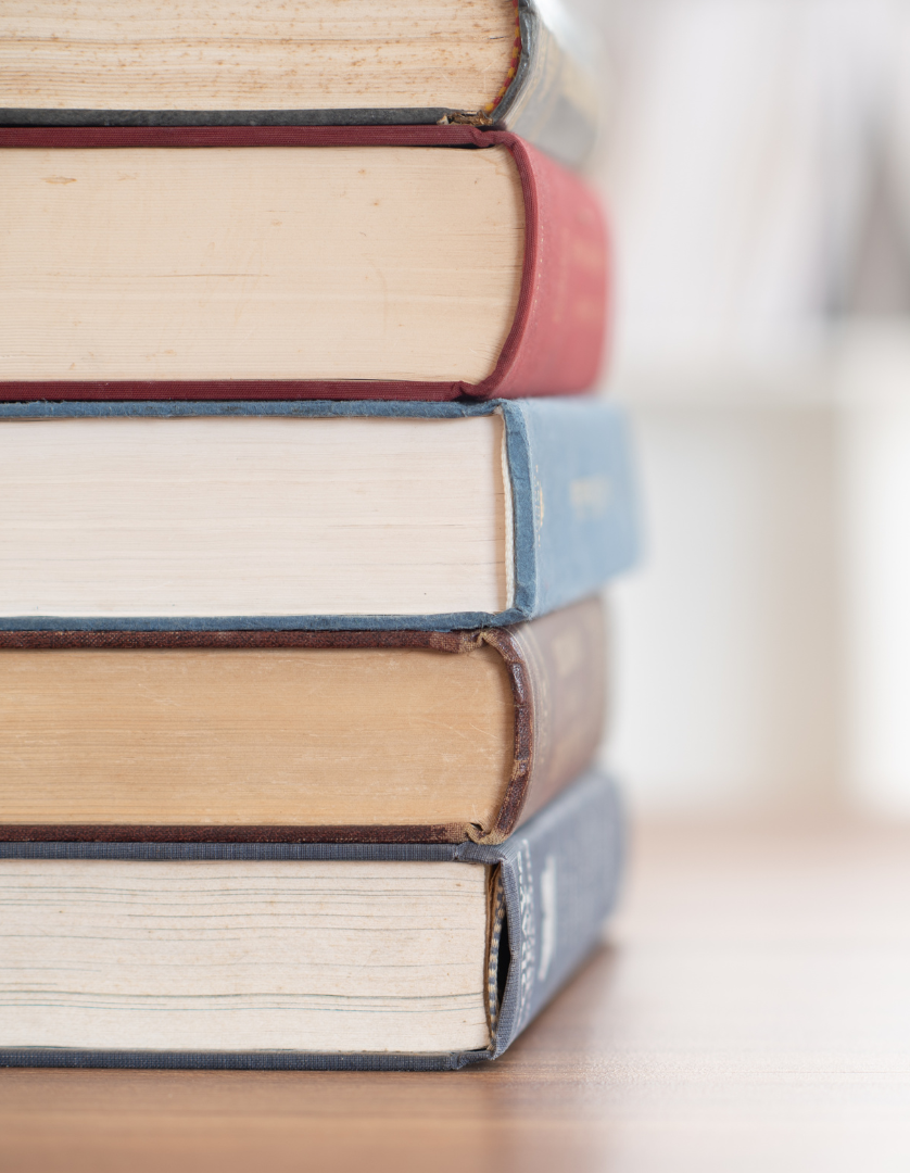 Four books are stacked on top of each other on a table
