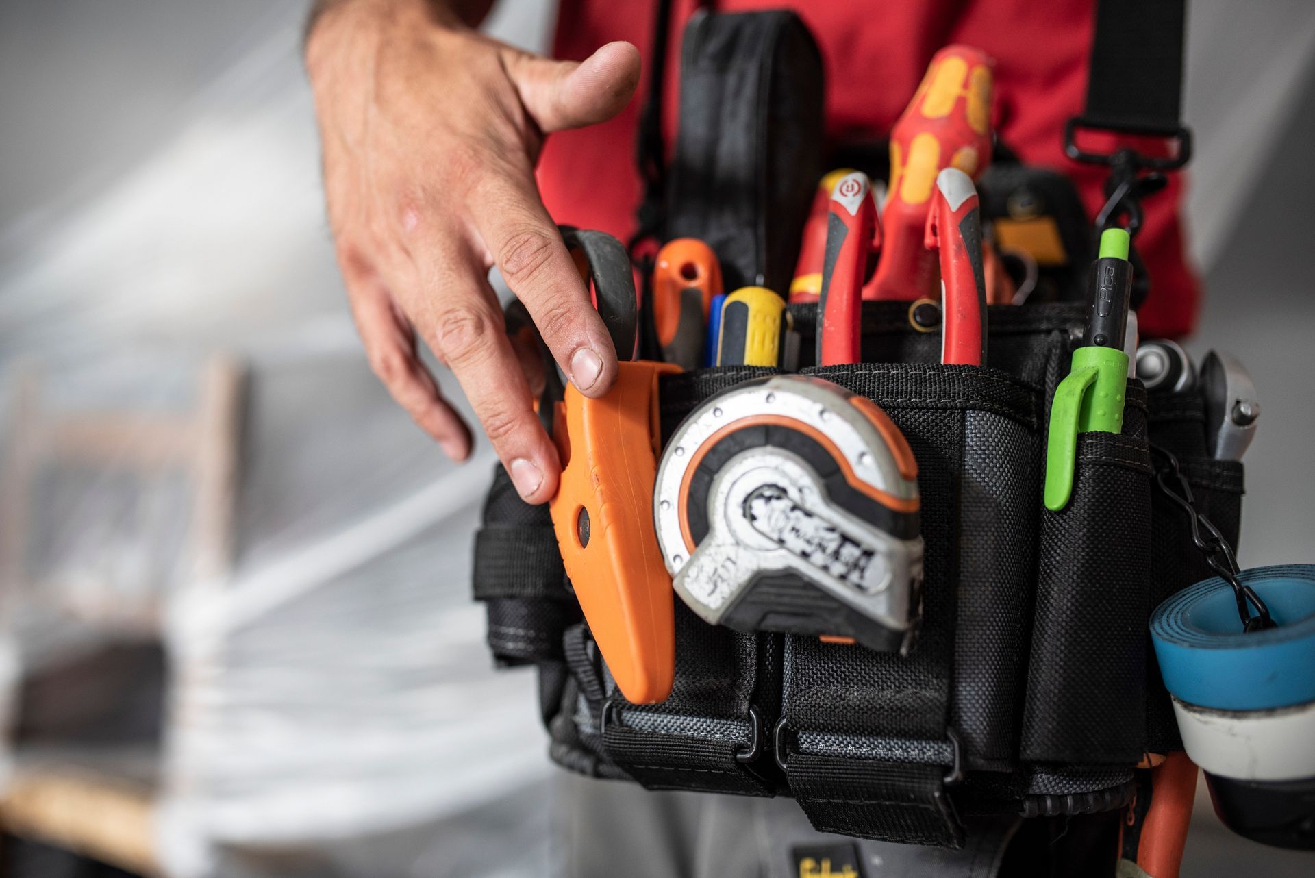 Tool belt loaded with essential hand tools used for professional plumbing services.