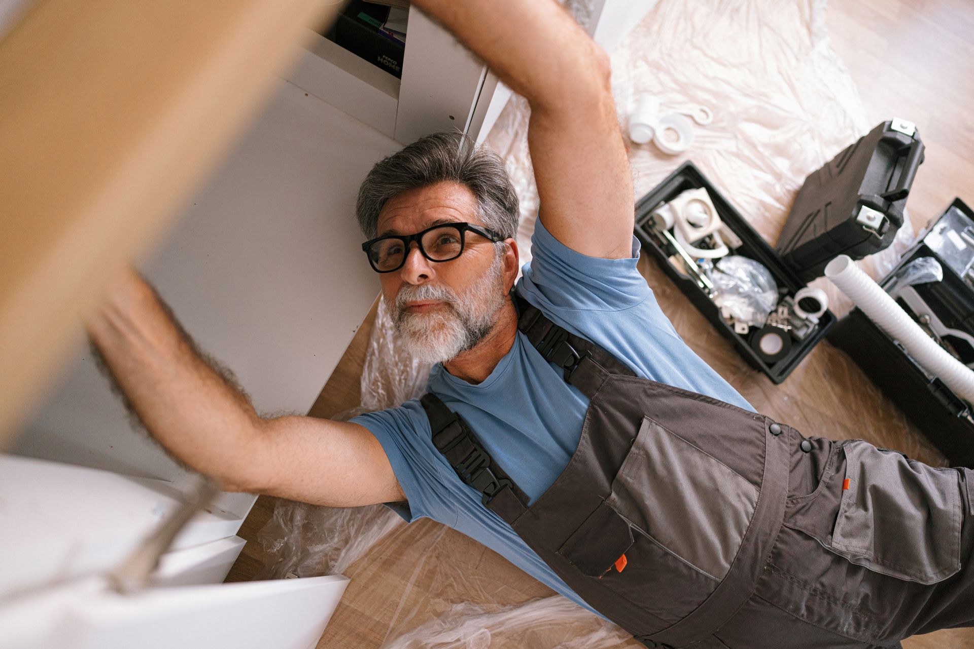 A plumber fixing a kitchen sink at a customer’s home.