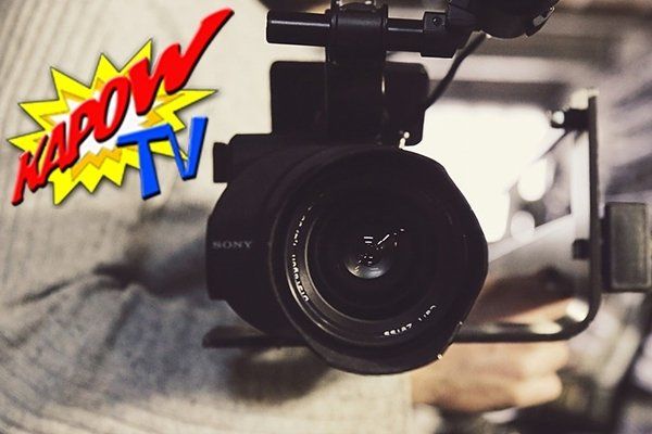 A close up of a camera with a kaboom tv logo in the background
