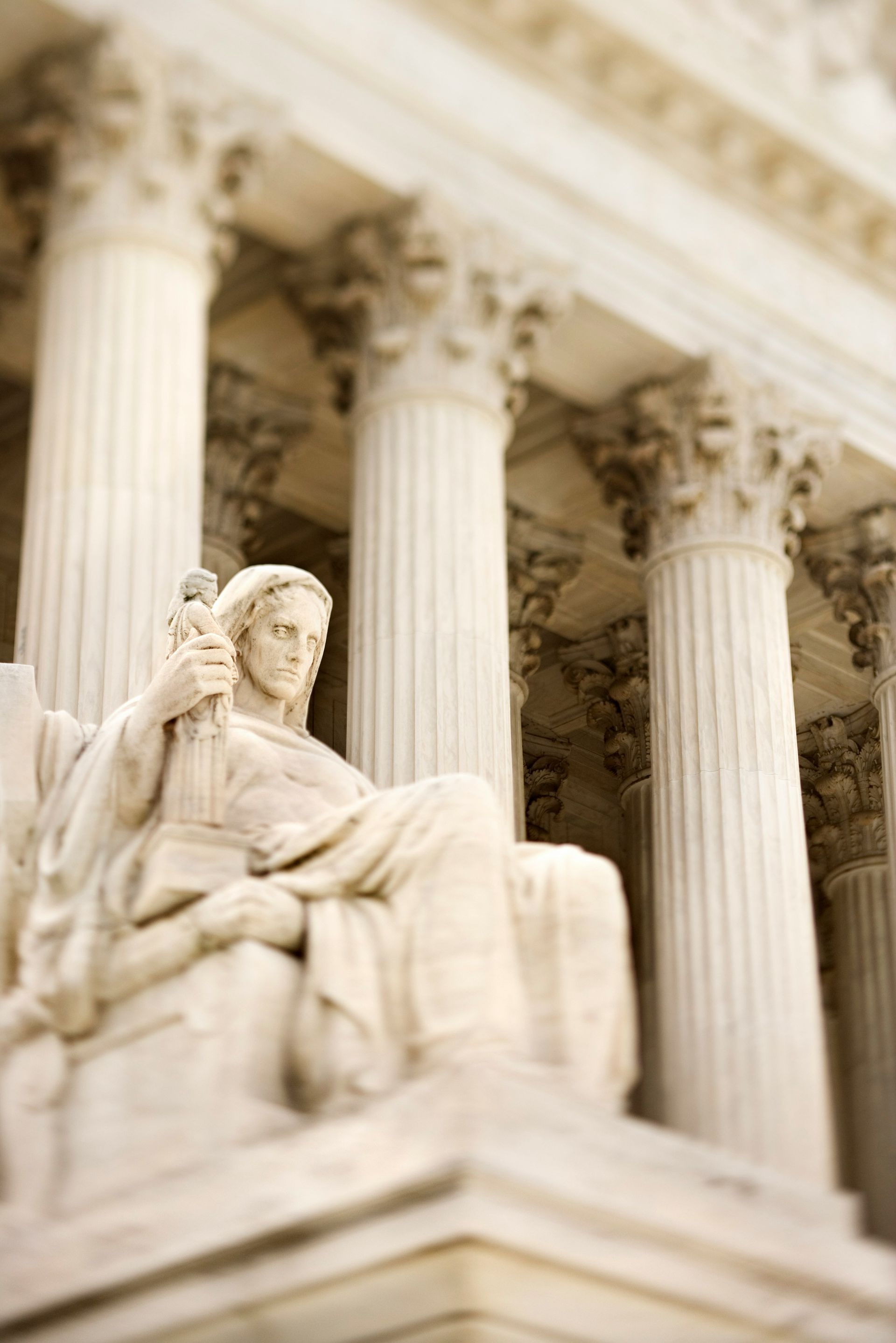 Marble seated statue before tall classical columns in a neoclassical building