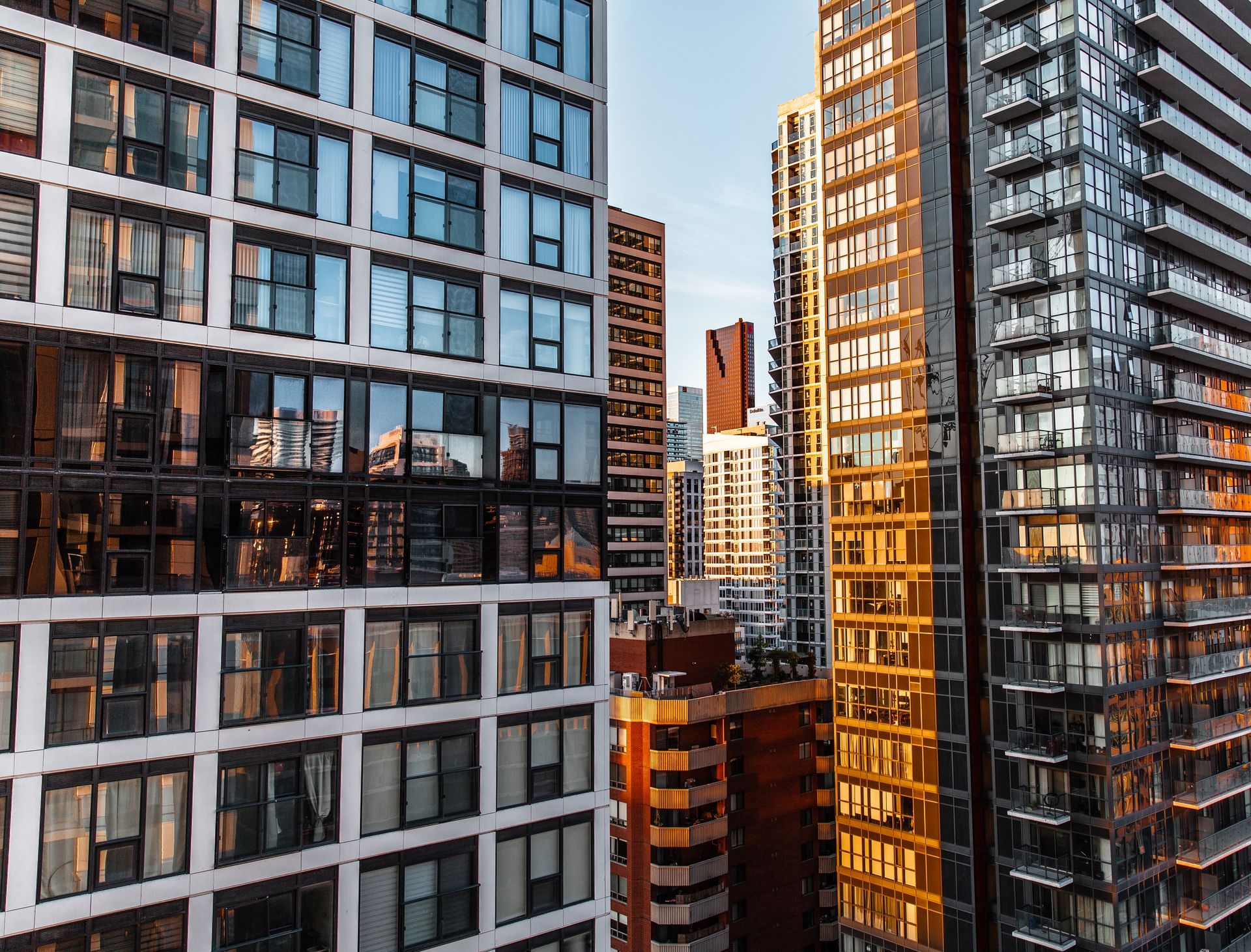 Modern high-rise apartment buildings with glass facades in warm evening light