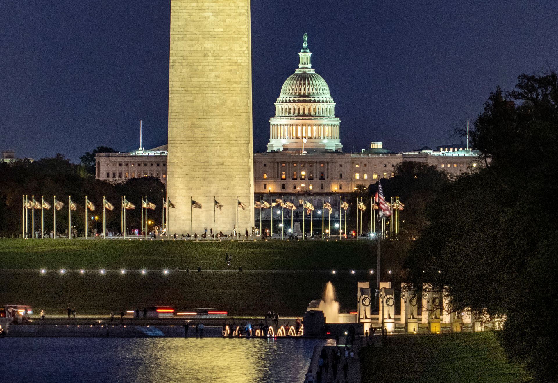 Night view of the Washington Monument and U.S. Capitol reflecting over water in Washington, D.C.