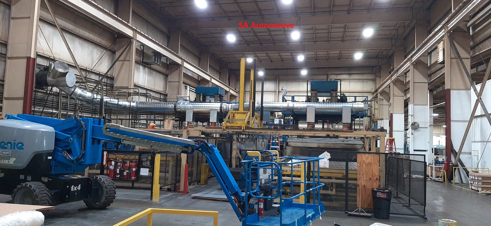 Large industrial workshop with a blue lift in the foreground.