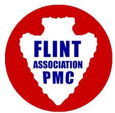 Logo of the Flint Association PMC. White arrowhead shape with blue text in red circle.
