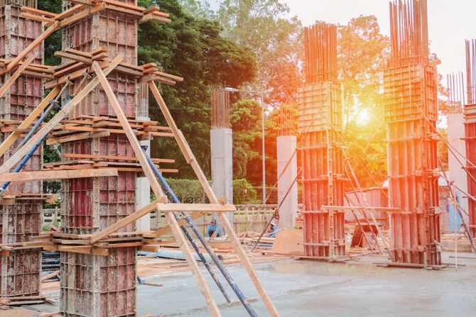 Un cantiere con molti pilastri di legno e impalcature.