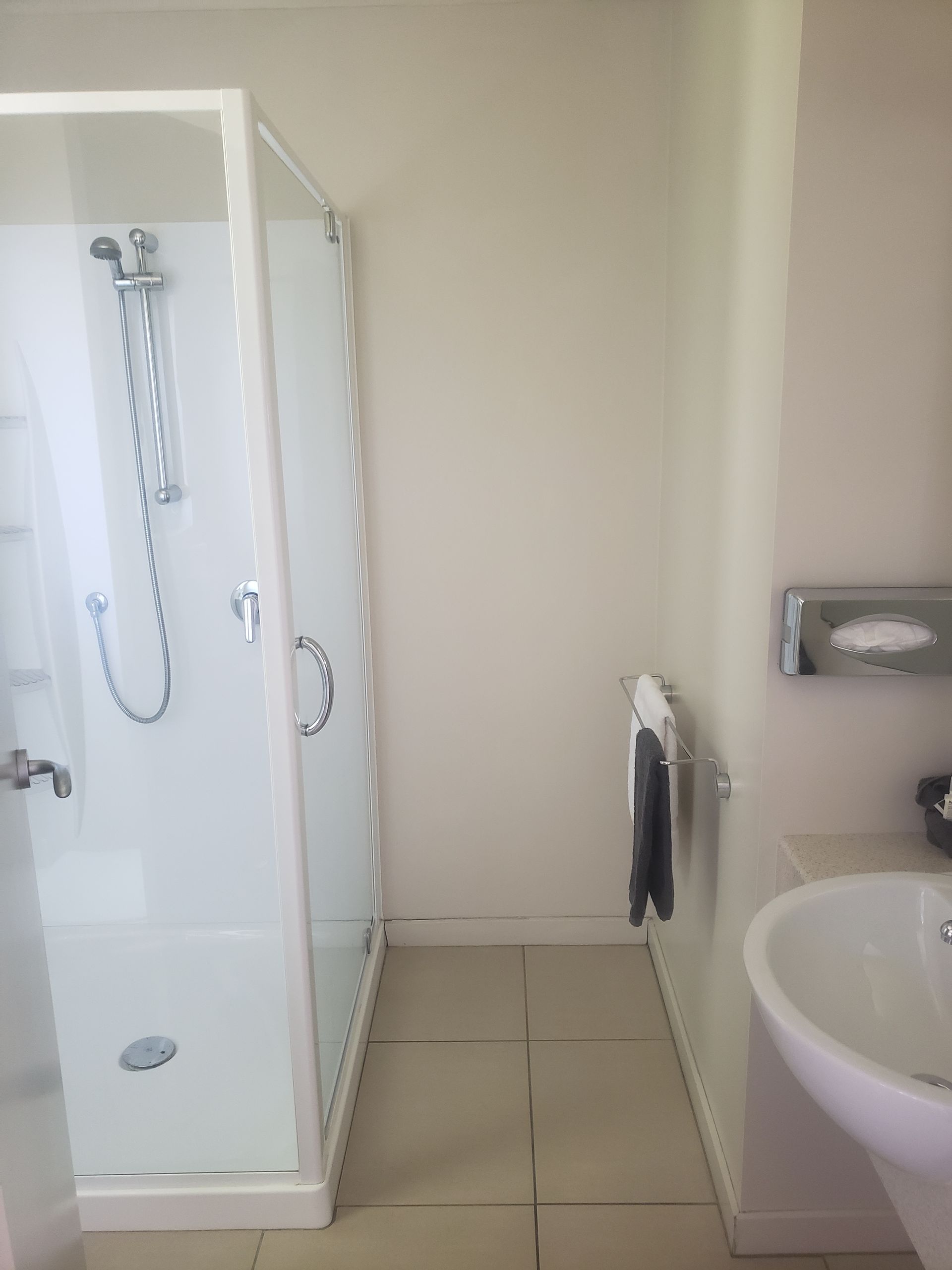 A bathroom with a shower , sink and toilet.