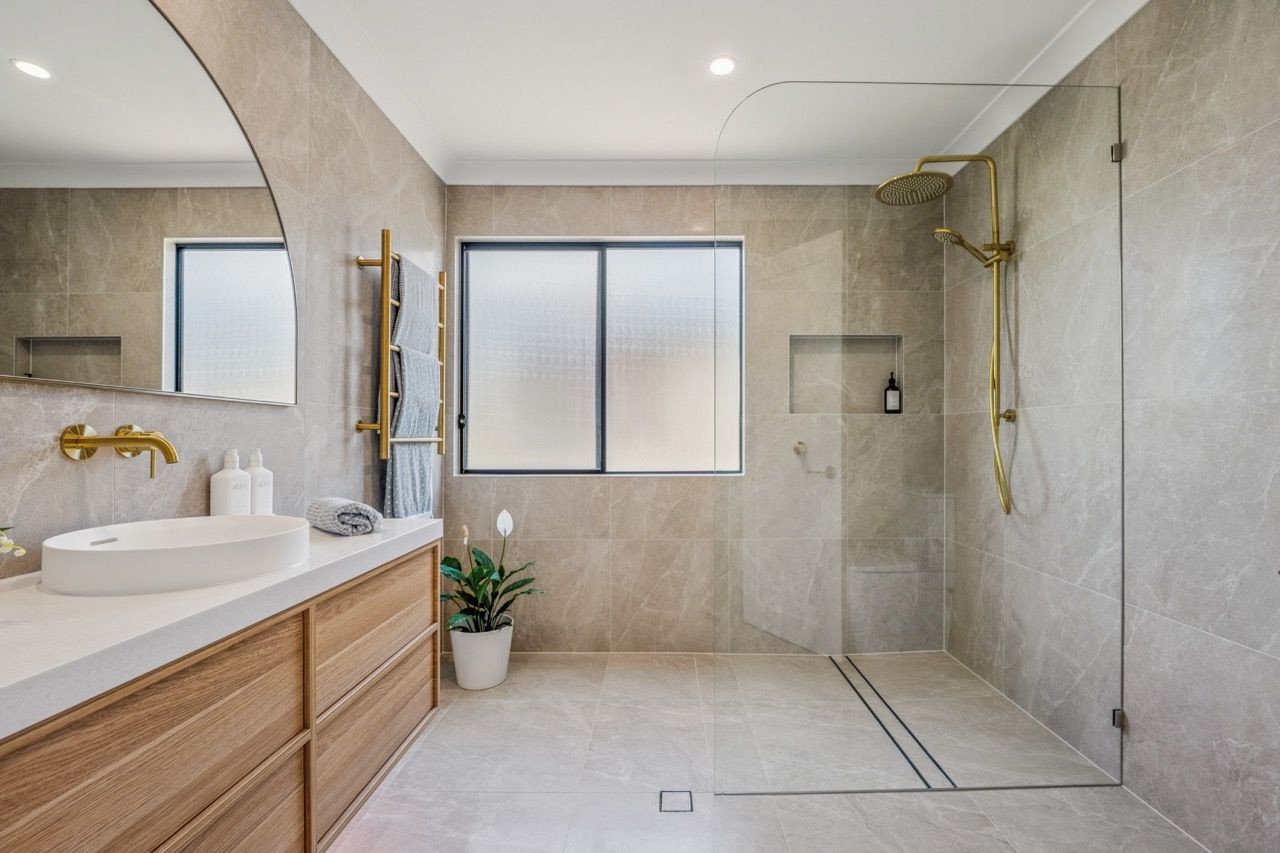 A bathroom with a walk in shower , toilet , sink and mirror.