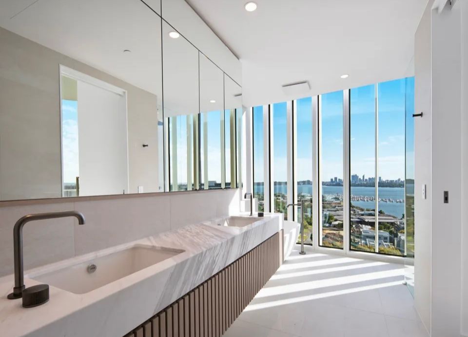 A bathroom with two sinks and a large window