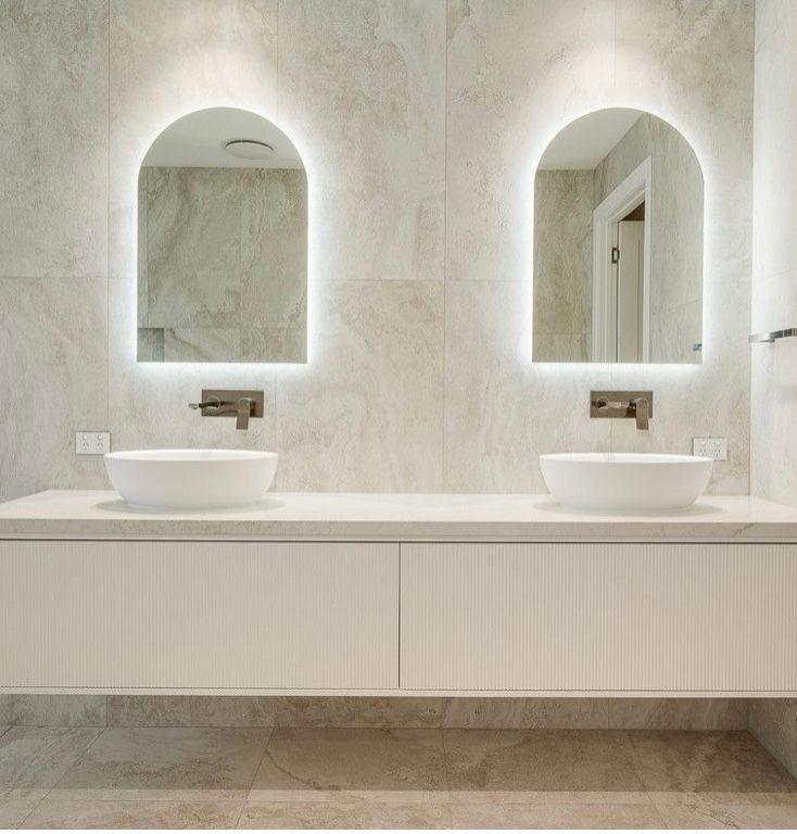 A bathroom with two sinks and two mirrors