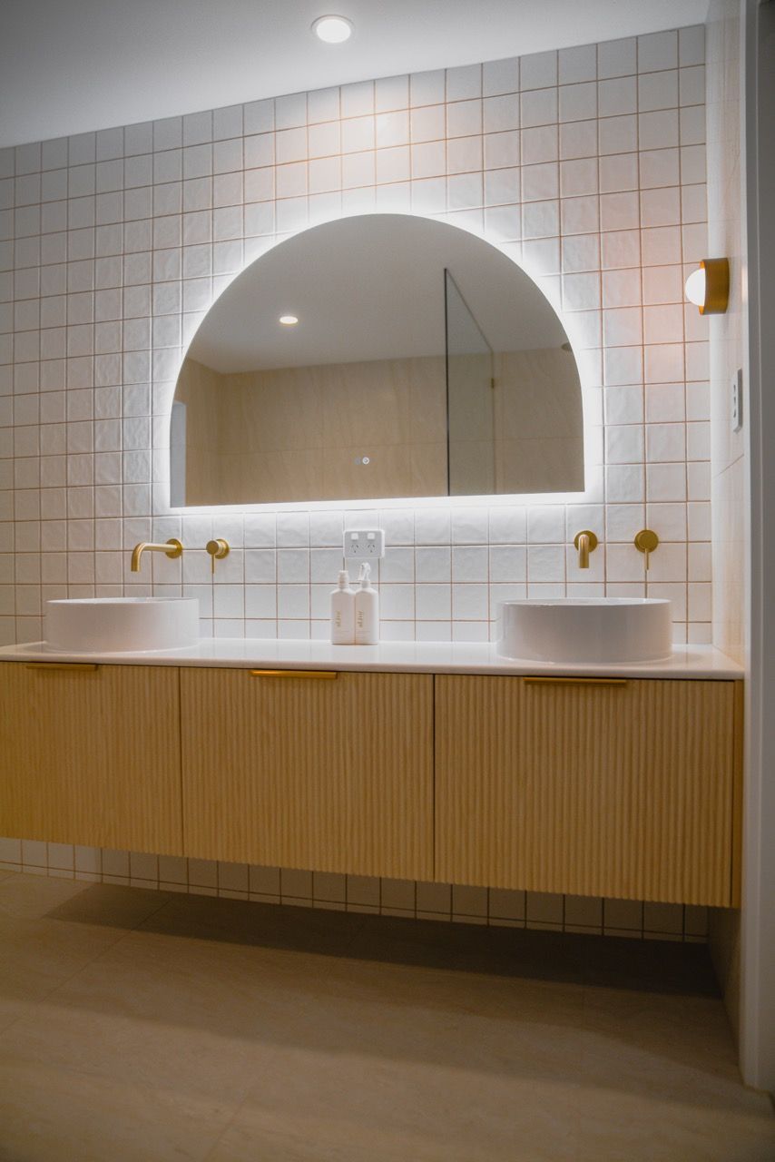 A bathroom with a bathtub , sink and mirror.