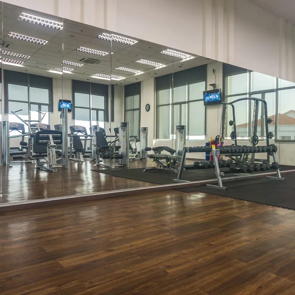A gym with a lot of mirrors and treadmills