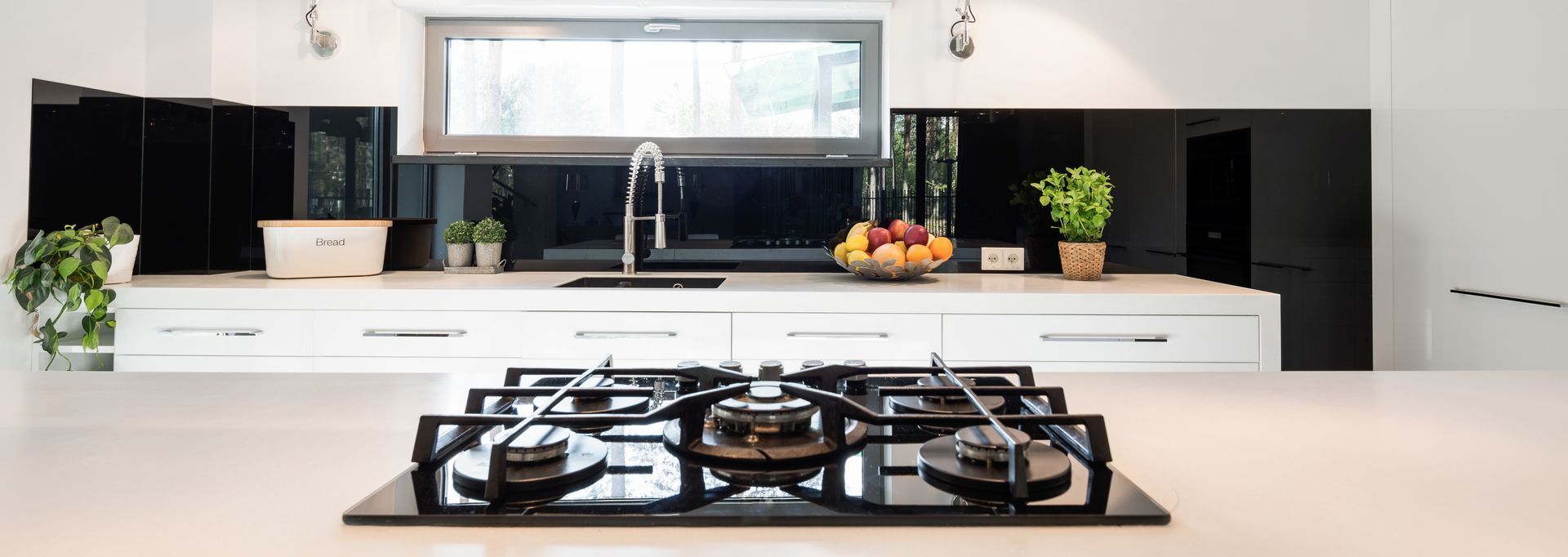 A kitchen with a stove top oven and a sink.