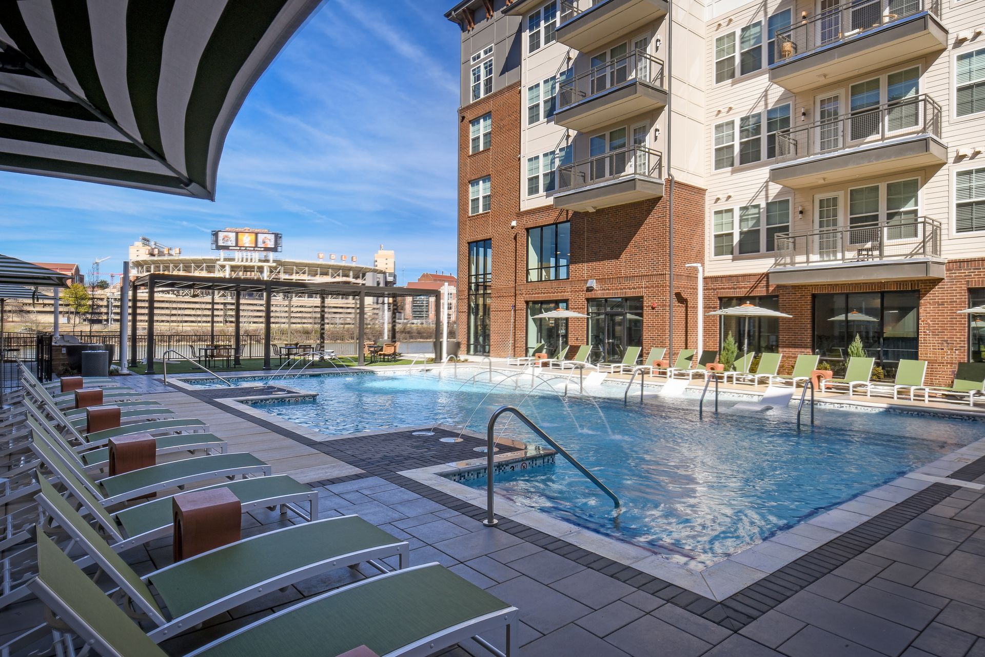 Shaded swimming pool flanked by lounge chairs at Livano Knoxville.