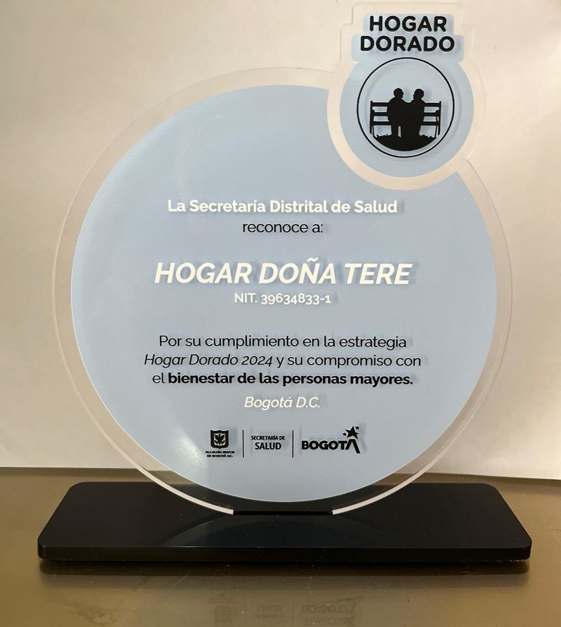Placa del premio “Hogar Doña Tere”, de Bogotá, Colombia, con detalles en dorado y negro.