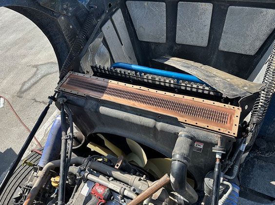 A close up of a car engine with the hood open