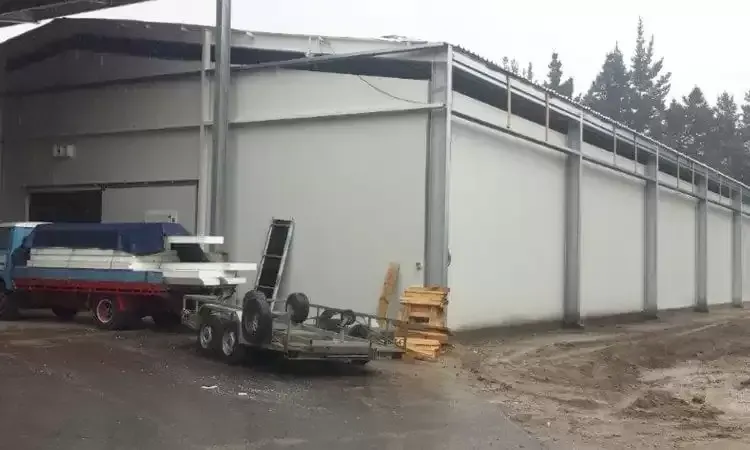 A trailer is parked in front of a large building.