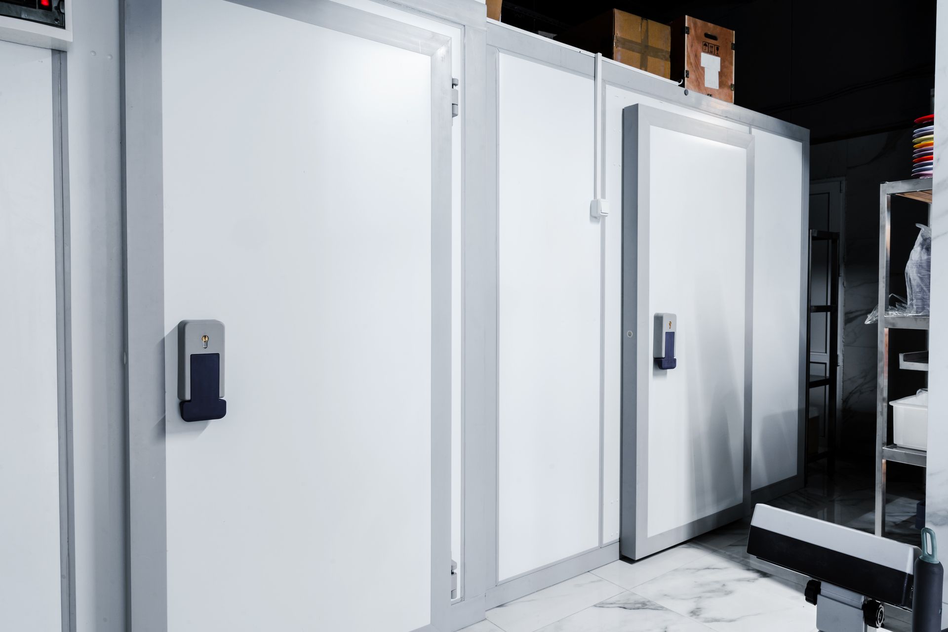 A room with a lot of white doors and boxes on the shelves.