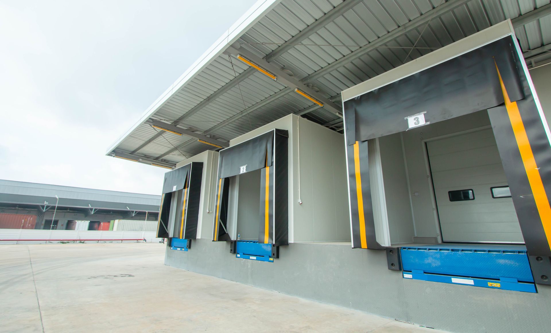 A warehouse with a lot of loading docks and a roof.