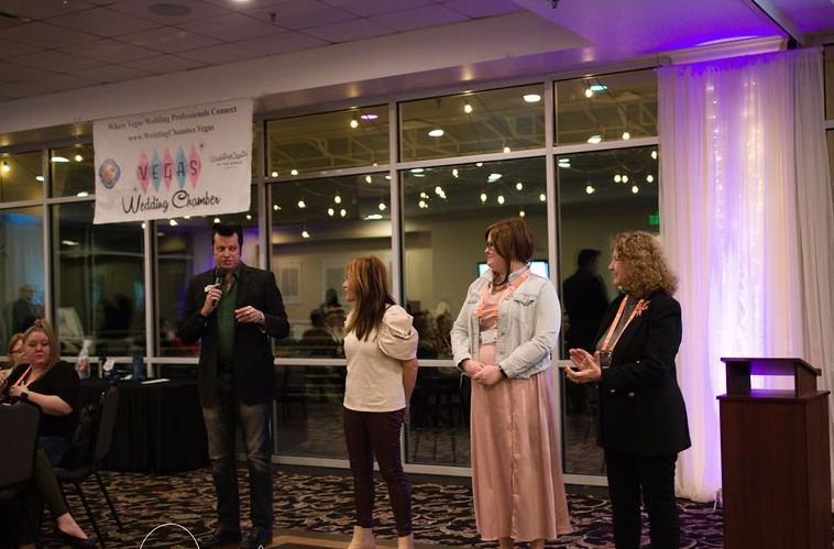 A group of people are standing in front of a microphone in a room.
