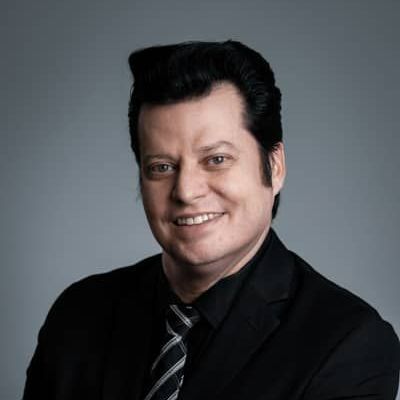 A man in a suit and tie is smiling for the camera.