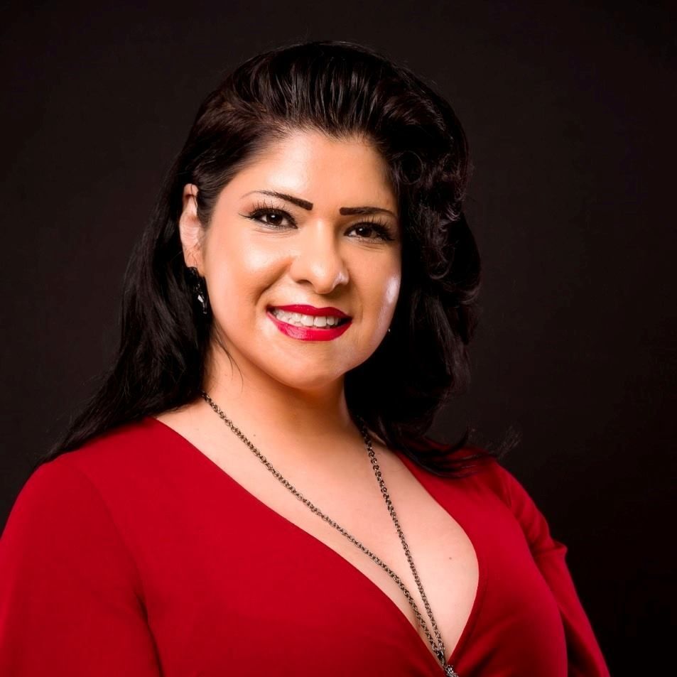 A woman in a red dress is smiling for the camera