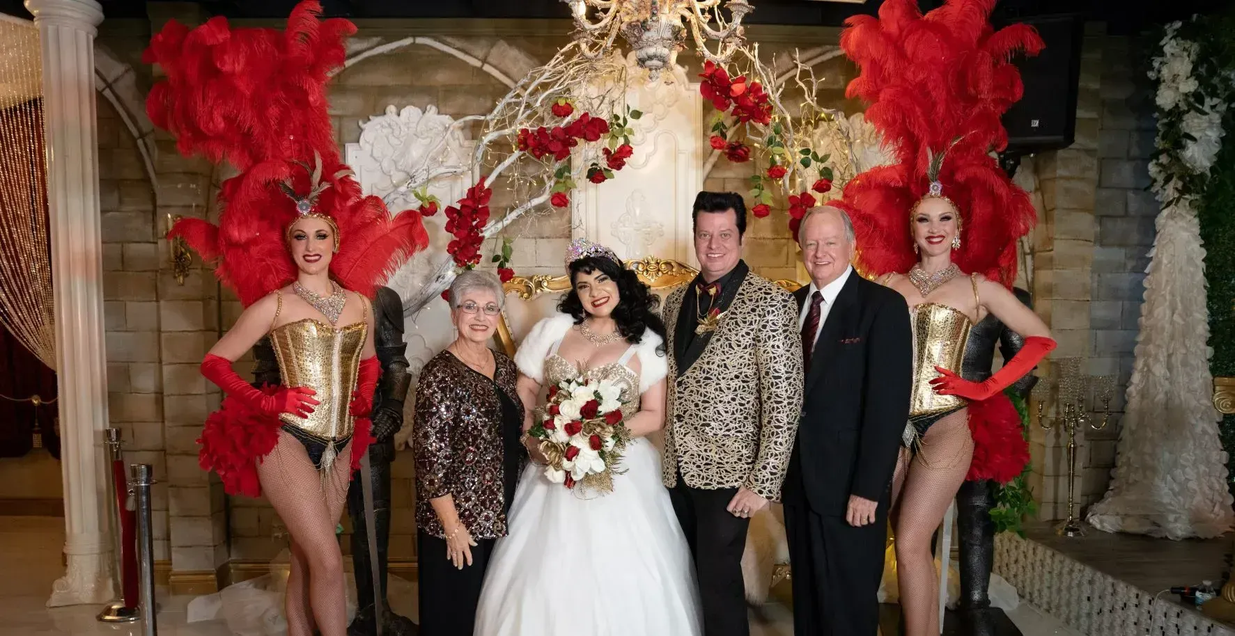 A group of people standing next to each other in front of a chandelier.