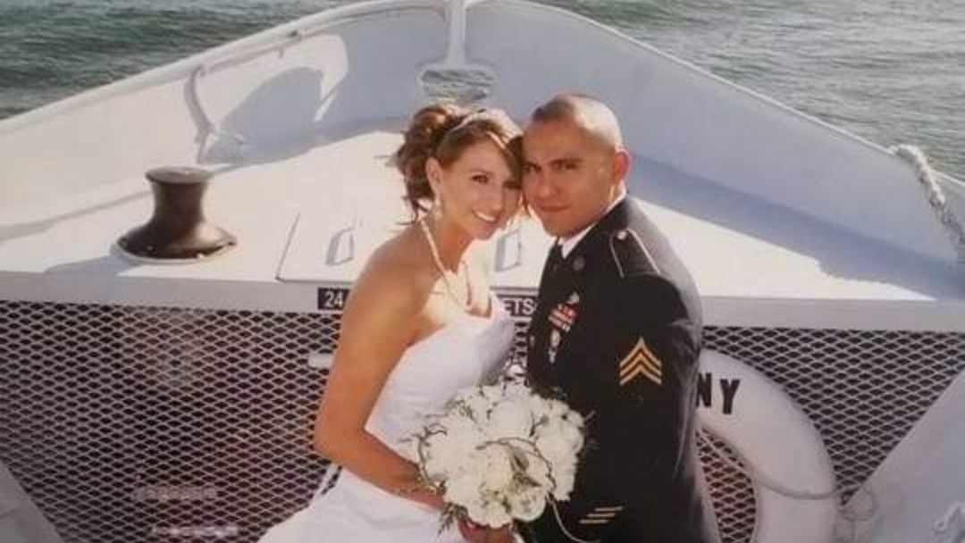 A bride and groom pose for a picture on a boat that says ny