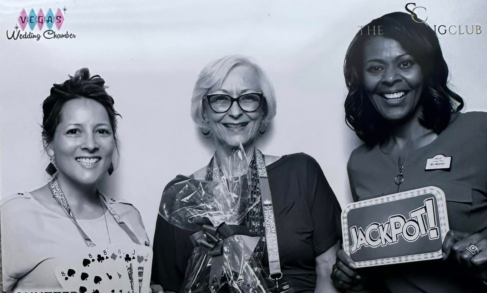 Three women are posing for a picture and one of them is holding a sign that says jackpot.