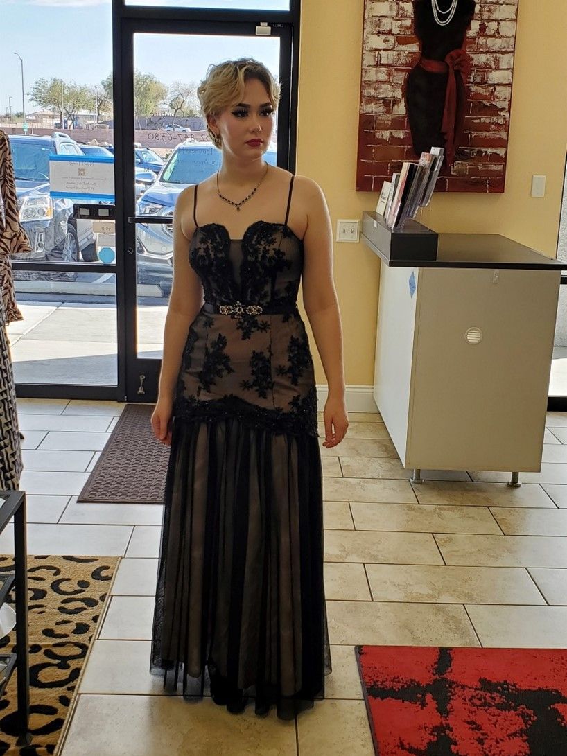 A woman in a black dress is standing in a store.