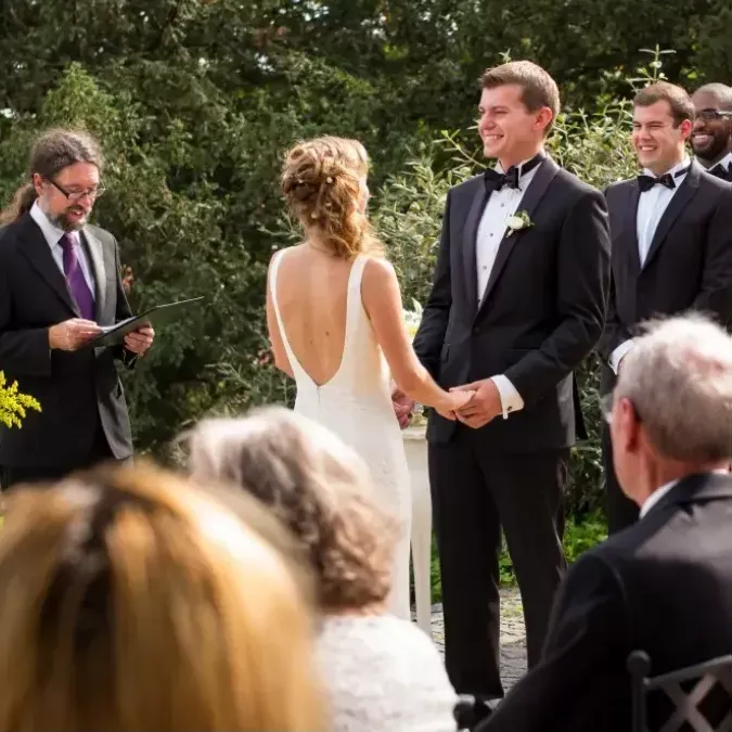 A bride and groom are holding hands during their wedding ceremony