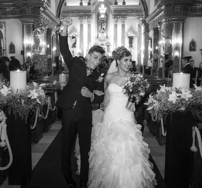 A black and white photo of a bride and groom in a church
