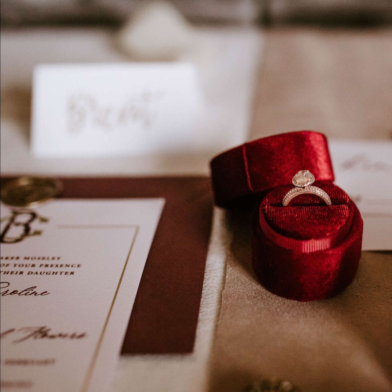 A wedding ring is in a red box on a table