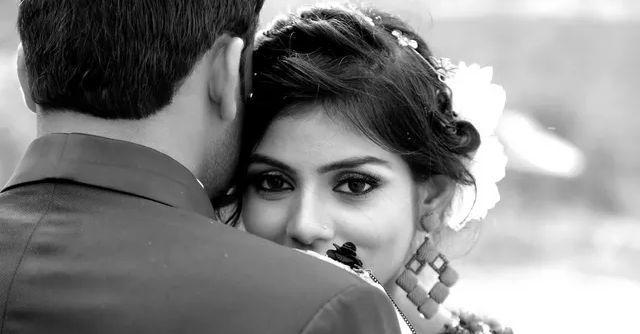 A man is hugging a woman in a black and white photo.