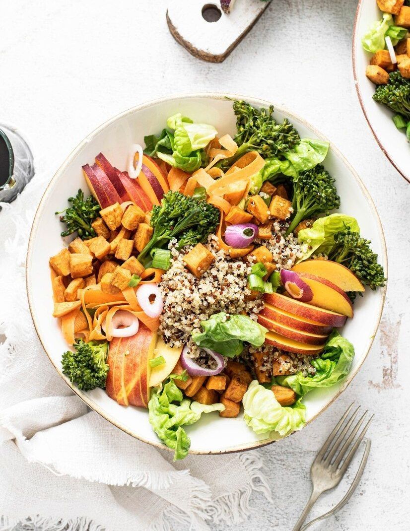 A white bowl filled with vegetables and rice on a table.