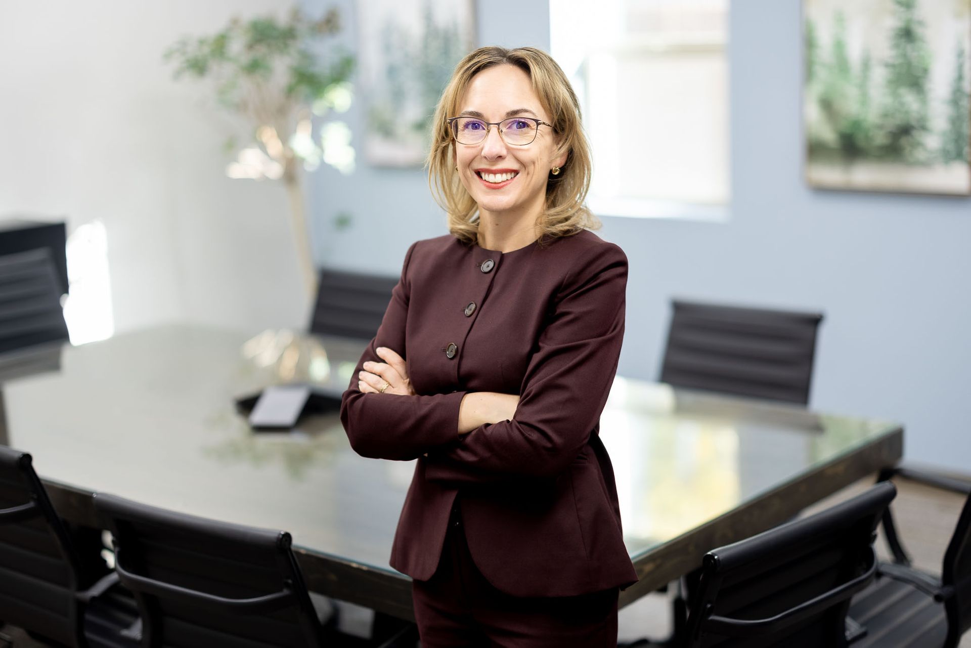 Shellie standing with arms crossed in a conference room